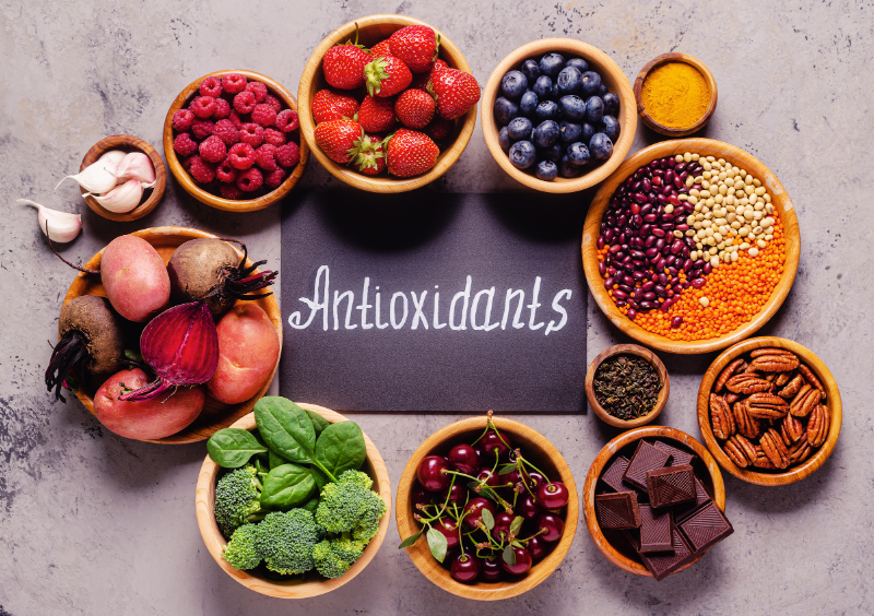 bowls of high-antioxidant foods around a chalkboard with the world antioxidant